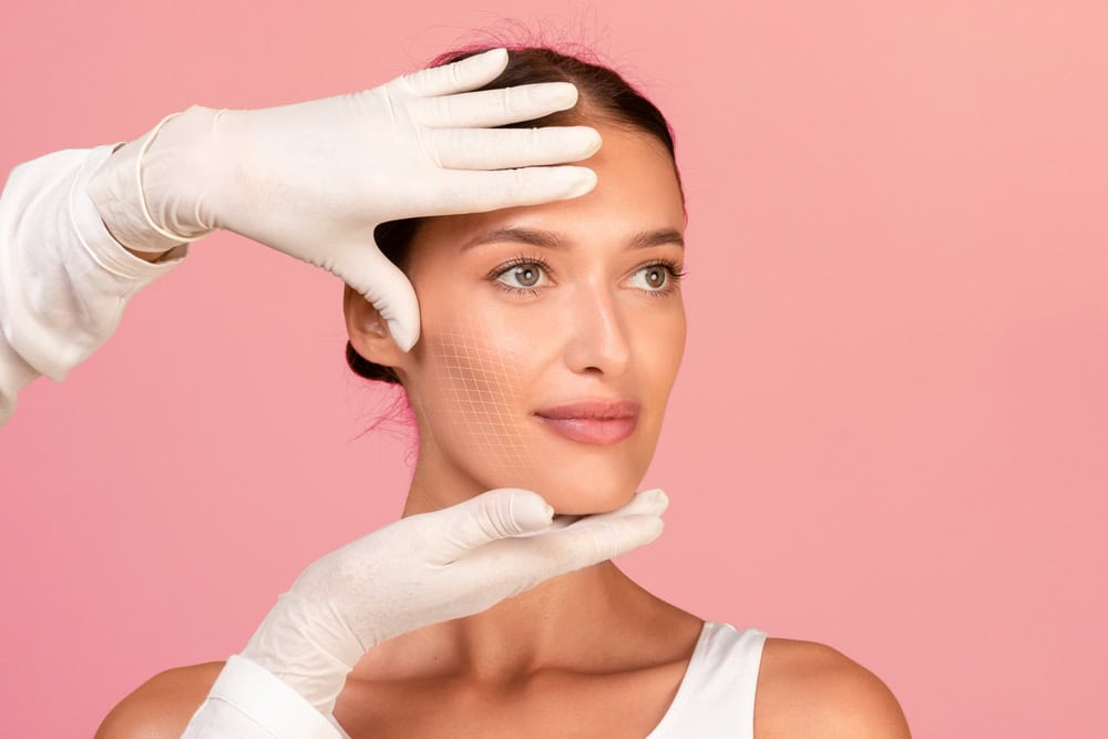 Woman's face with surgeon's hands during facelift consultation in Cleveland, OH