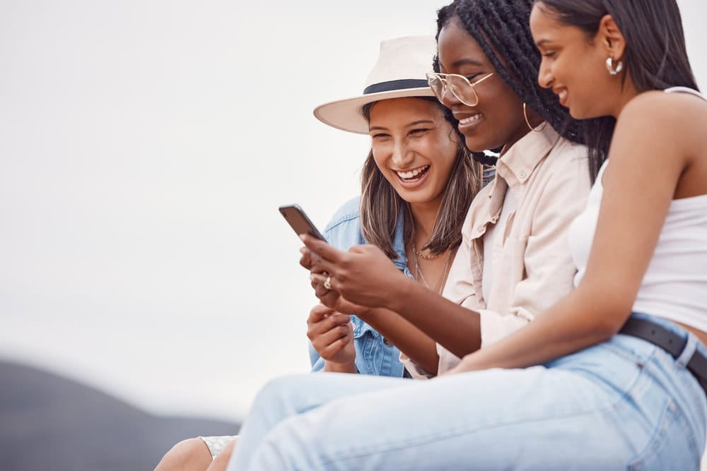 Group of women looking at a social media on a phone.